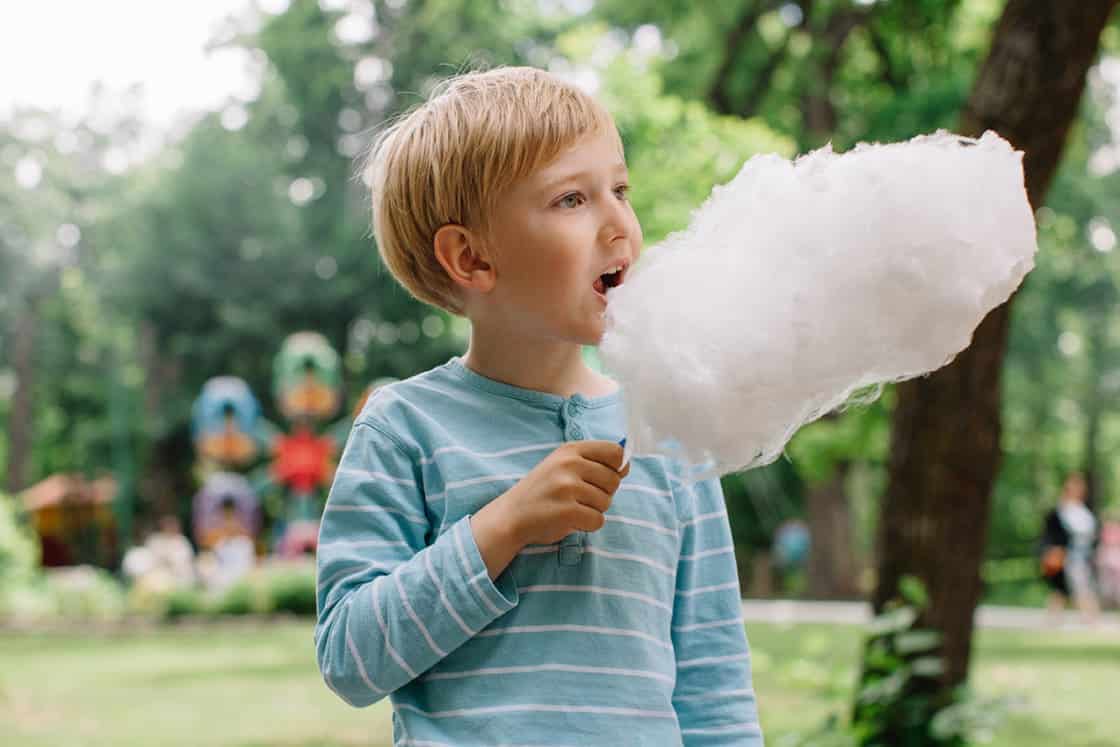 Blond Boy Eating Candyfloss In The Summer Amusement Park مجلة نقطة العلمية