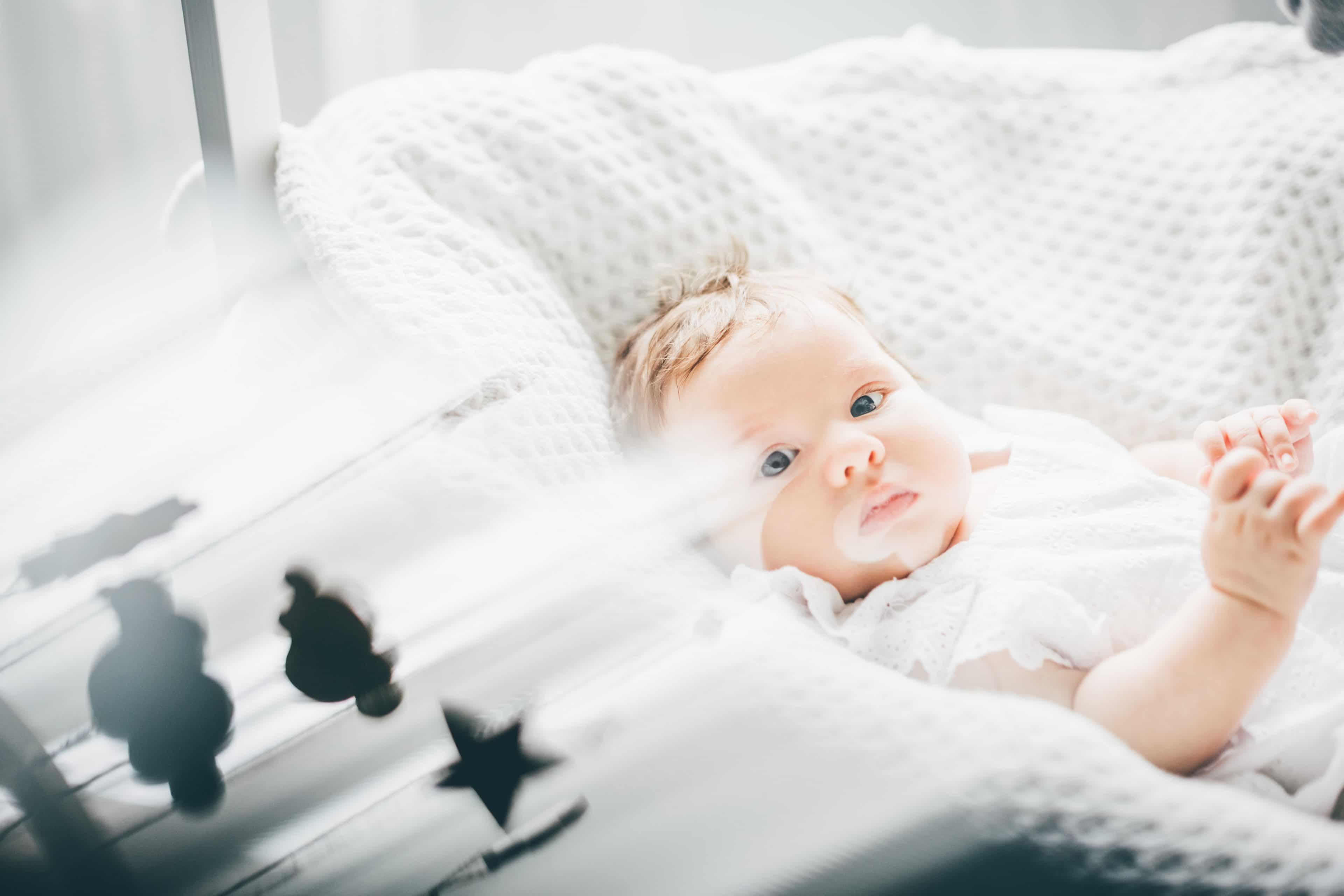 two month old baby girl lying on the bad QGV2FQ8 scaled الطفل الرضيع من عُمر شهر إلى 3 أشهر مجلة نقطة العلمية