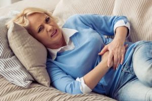 Woman Stomach Pain Sofa مجلة نقطة العلمية