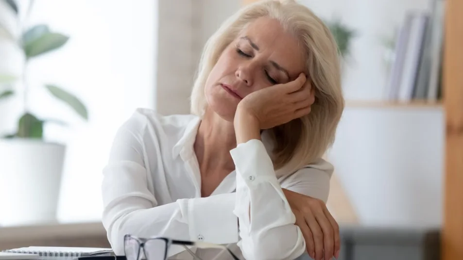 Mature Woman Falling Asleep At Desk Menopause Insomnia Concept مجلة نقطة العلمية