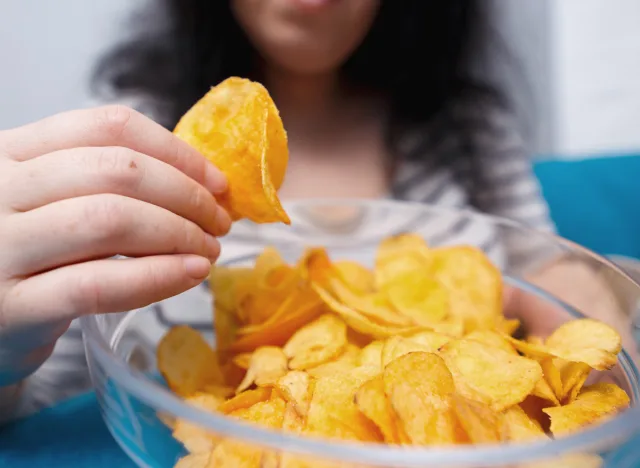 Woman Eating Potato Chips Bowl مجلة نقطة العلمية