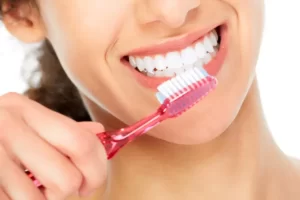 Smiling Woman Brushing Teeth E1650935114194 مجلة نقطة العلمية